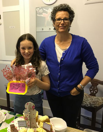 Child and parent with cakes for Macmillan Cancer Support